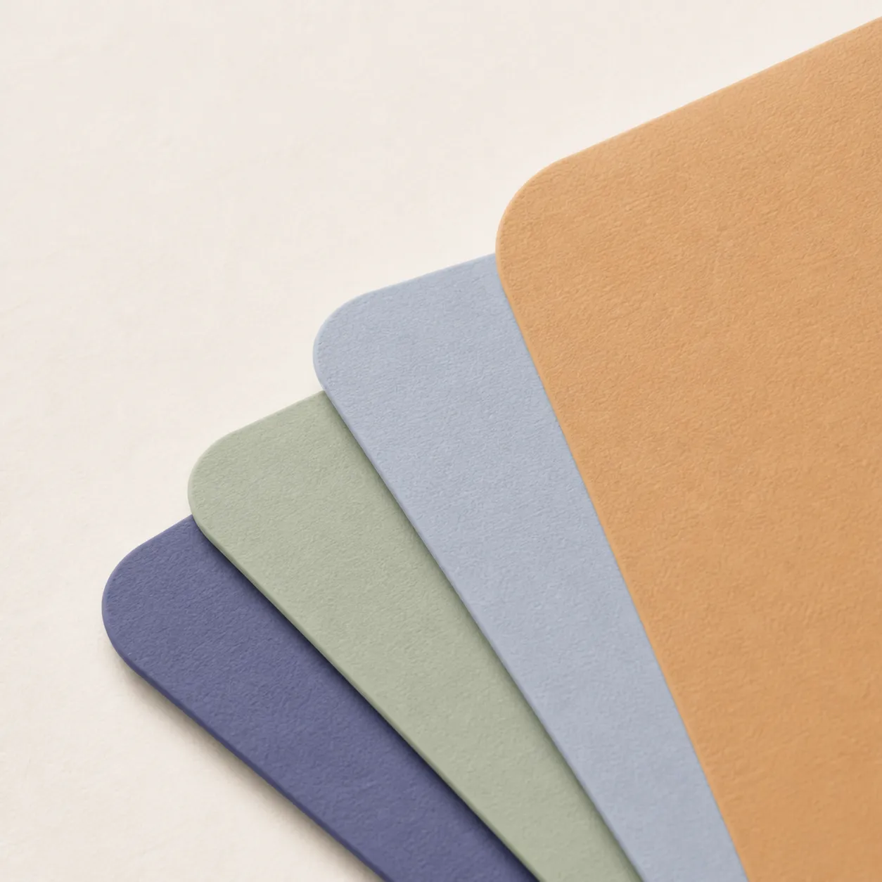 Four paper layers fan across an ivory surface.